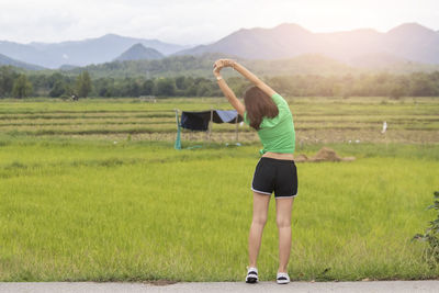 Rear view of woman standing on field