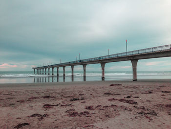 Bridge over calm sea against sky