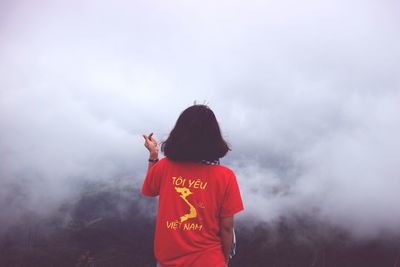 Rear view of girl standing against sky