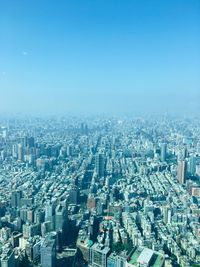 High angle view of modern buildings in city against clear blue sky