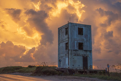 Abandoned building against sky during sunset