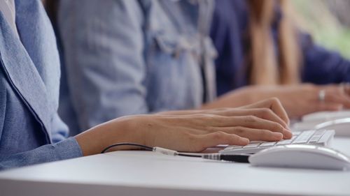 Midsection of woman using smart phone on table