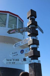 Low angle view of information sign against sky