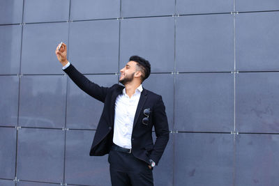 Young man looking away against wall