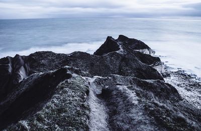 Rocks in sea against sky