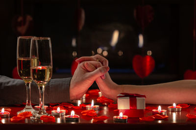 Close-up of hand holding wine glasses on table