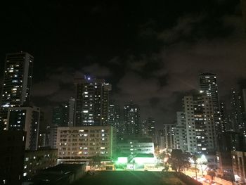 High angle view of illuminated buildings against sky at night