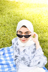 Portrait of woman wearing sunglasses on field