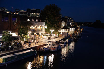 Boats moored in canal at night