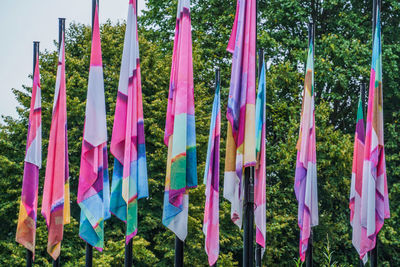 Multi colored flags hanging on pole in field