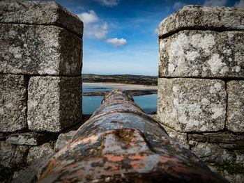 Close-up of old stone wall against sky