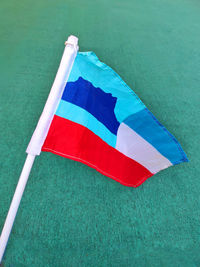High angle view of multi colored sabah flag on green background