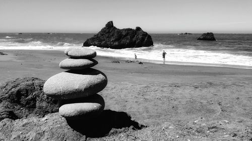 Stack of rocks on beach against sky