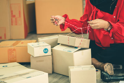 Full length of man holding toy while standing in box