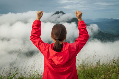 Rear view of woman standing on landscape against sky