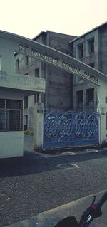 Graffiti on building against sky in city