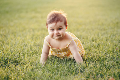 Baby girl crawling on ground in park outdoors. adorable child toddler exploring studying the world 
