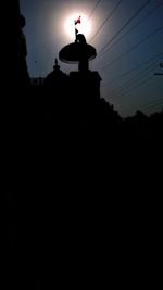 Low angle view of electricity pylon at night