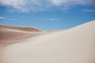 Sand dunes in desert against sky