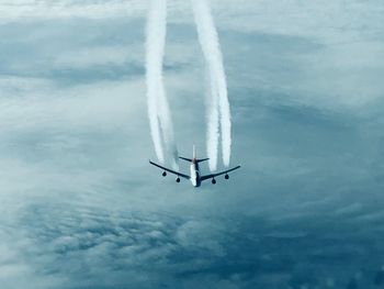 Low angle view of airplane in flight against sky