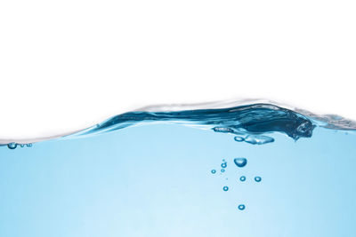 Close-up of water splashing against blue background
