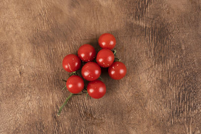 Branch of red cherry tomatoes on the wooden background. delisious healthy food, ripe vegetables.