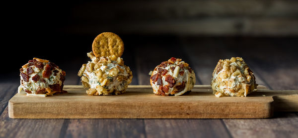 A row of dill pickle fat bombs for spreading on crackers, on a wooden board.