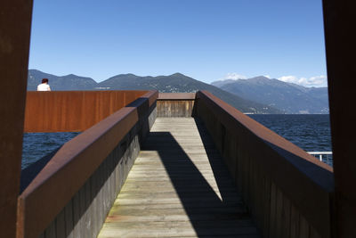 Scenic view of sea and mountains against clear blue sky