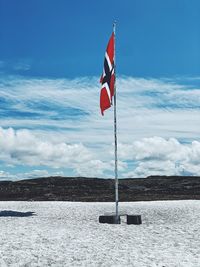 Flag on pole against sky