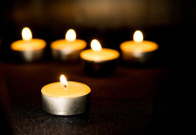 Close-up of illuminated tea light candles on table