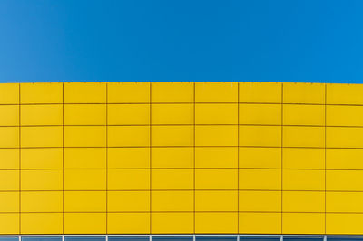 Full frame shot of yellow wall against blue sky 
