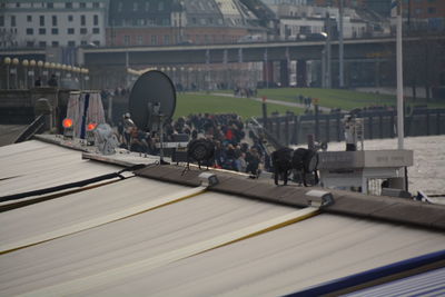 Lighting equipment and satellite dish on roof with people in background