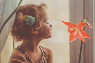 Close-up of cute girl with daylily at home