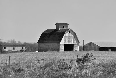 Abandoned barn on field against clear sky