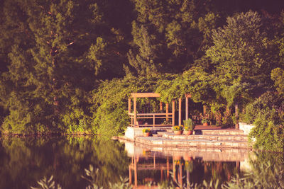 Built structure in lake against trees in forest