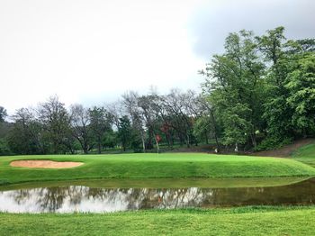 Scenic view of golf course against sky