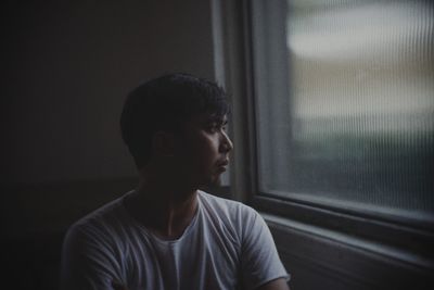 Young man looking towards window at home