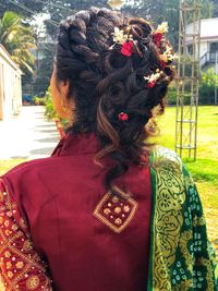 Rear view of woman standing by flowers