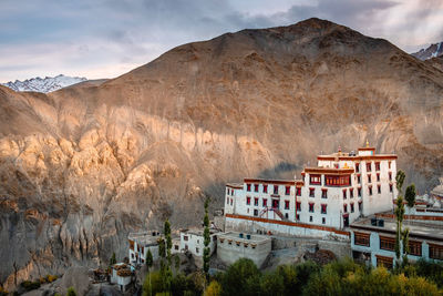 Panoramic view of buildings and mountain against cloudy sky