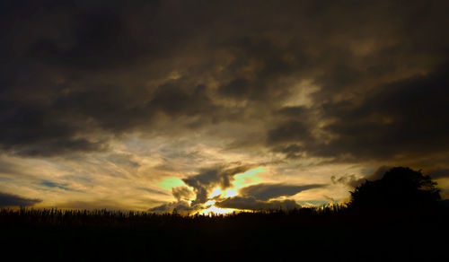 Scenic view of dramatic sky over silhouette landscape