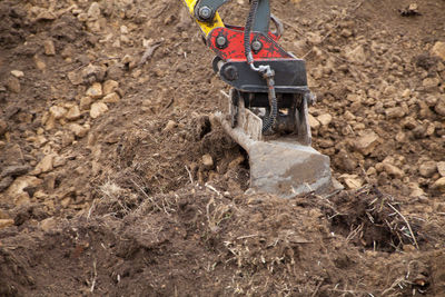 High angle view of earth mover digging dirt at construction site