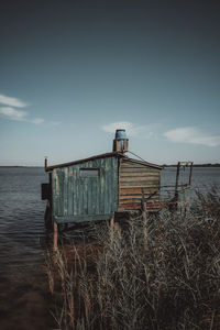 Abandoned built structure on beach against sky