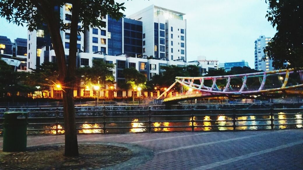 architecture, built structure, building exterior, city, water, tree, railing, bridge - man made structure, illuminated, connection, reflection, sky, building, outdoors, river, street light, residential building, no people, street, bridge