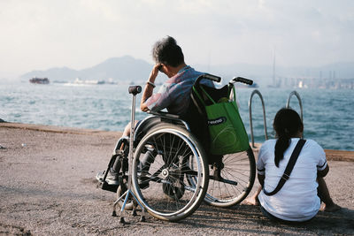 Rear view of people riding bicycle on beach