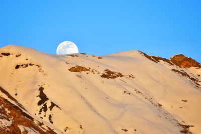 Ce soir, la lune roule sur la crête des montagnes.