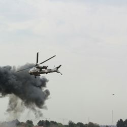 Low angle view of helicopter flying by smoke in sky