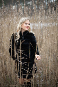 Portrait of beautiful woman standing on field