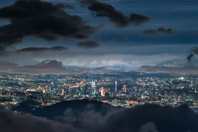 Illuminated city against sky at night