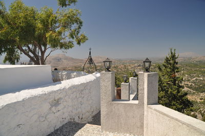 Surrounding wall of tsambika monastery by landscape against clear sky