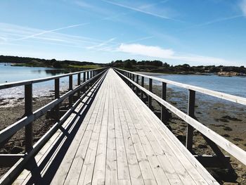 Footbridge over river against sky